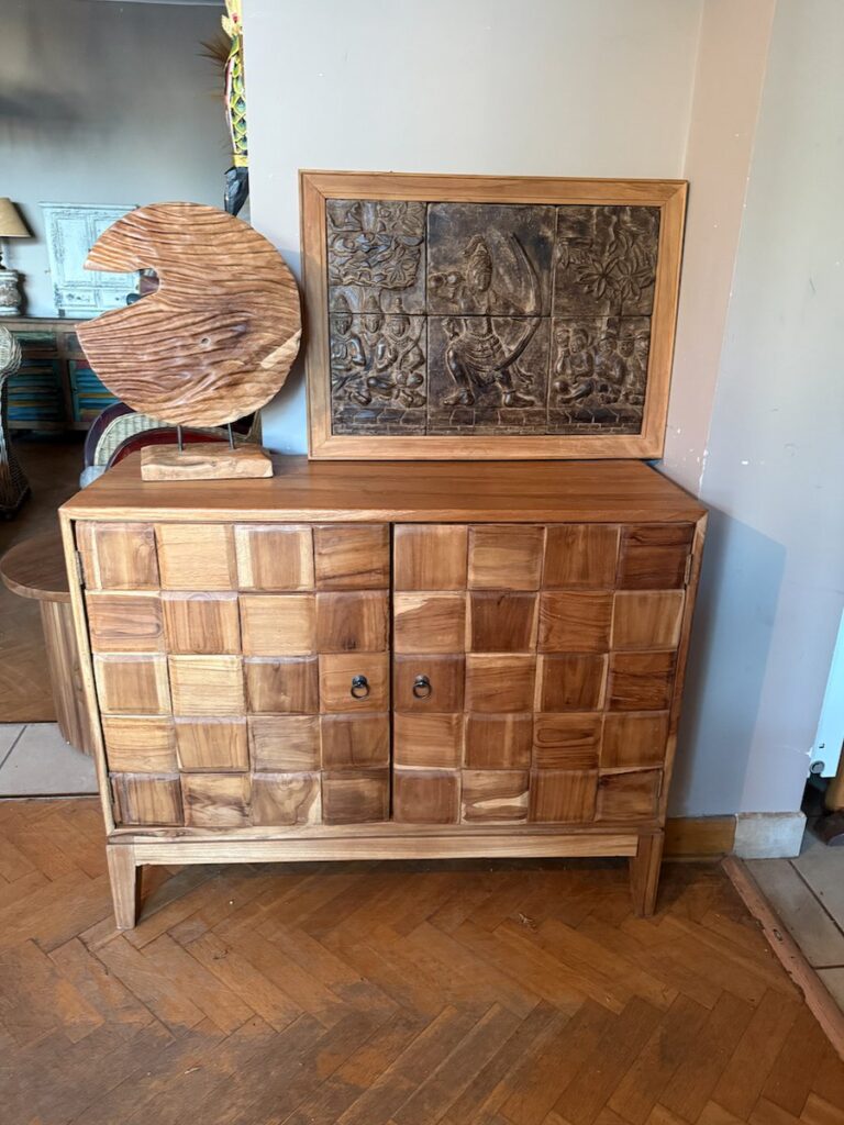 Drewniana komoda z frontami w szachownice i rzezbiony panel w salonie meble-teak