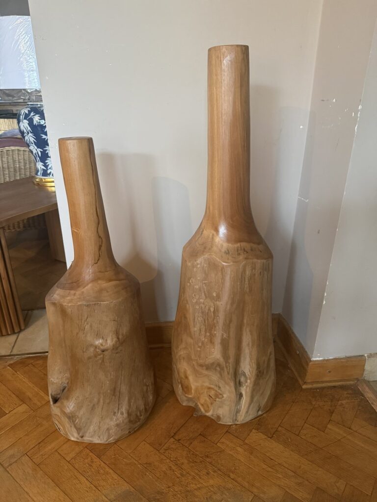 Dwie rzeźby z korzenia tekowego w kształcie butli, 100 i 80 cm, na jodełce w salonie Meble Teak