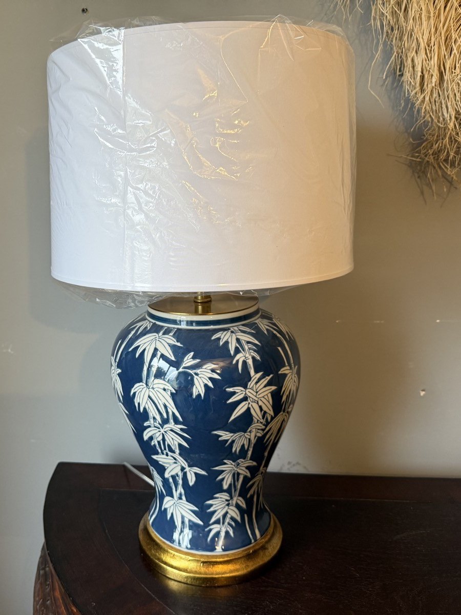 Lampa z białym abażurem na ciemnej półokrągłej konsoli